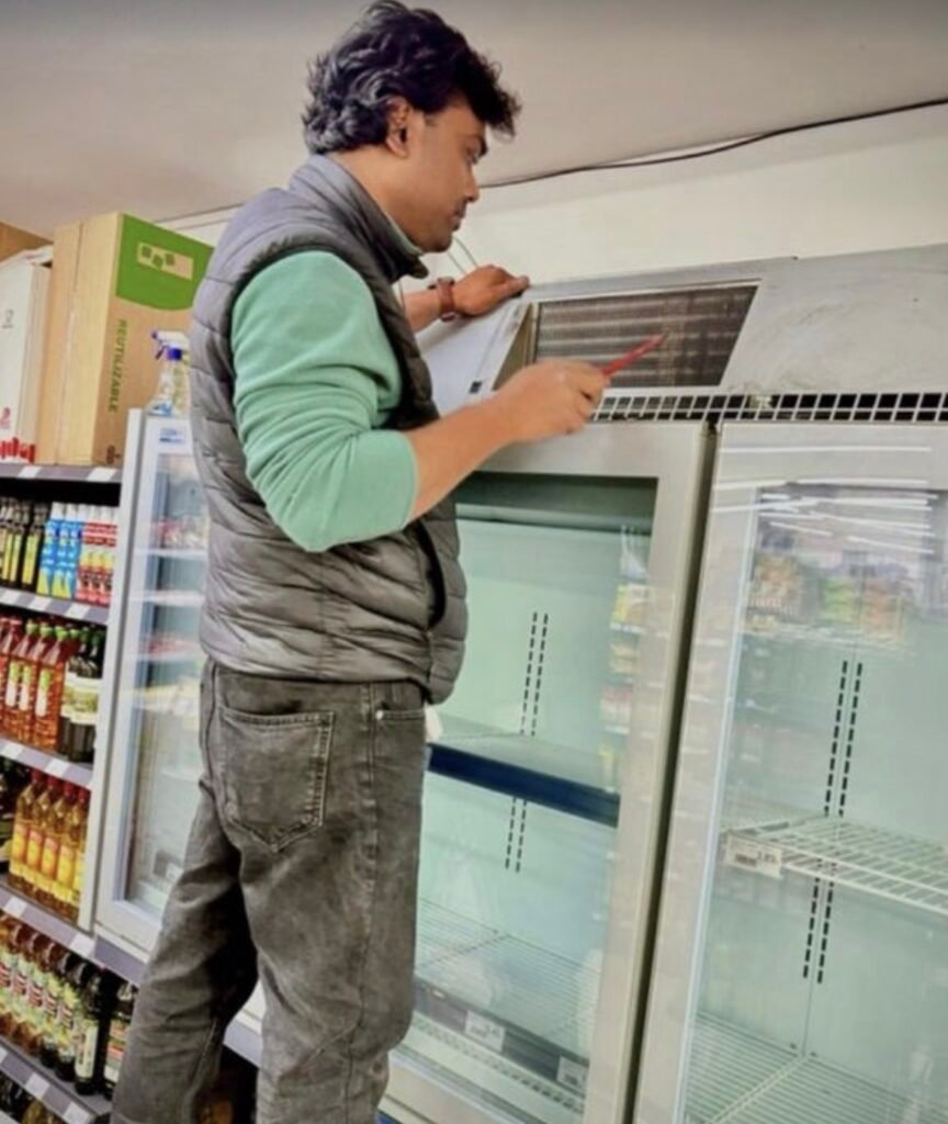 Técnico revisando una vitrina expositora refrigerada en un comercio de Barcelona