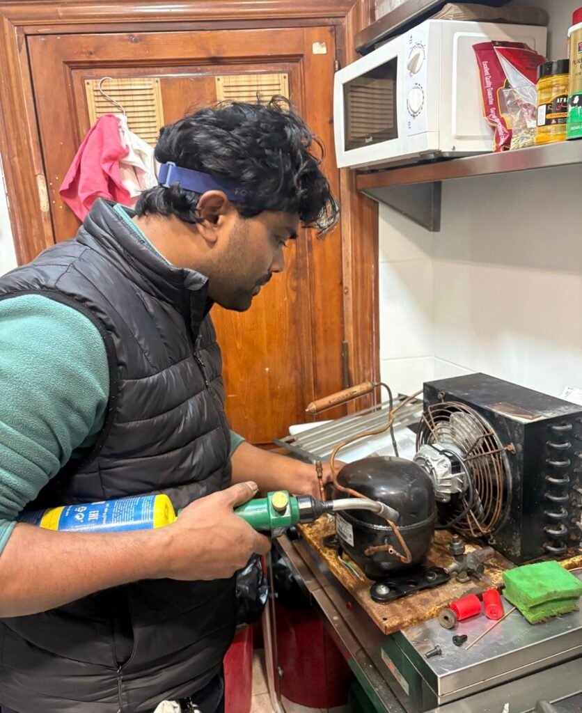 Técnico soldando las tuberías de cobre tras instalar un compresor nuevo en un equipo de refrigeración