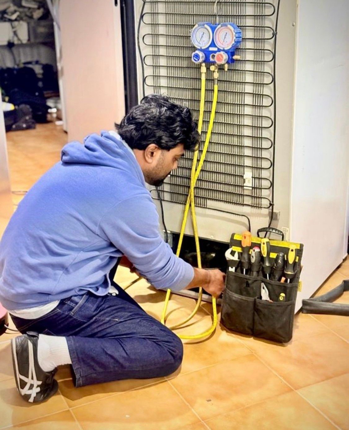 Técnico recargando gas refrigerante en un frigorífico doméstico en Barcelona