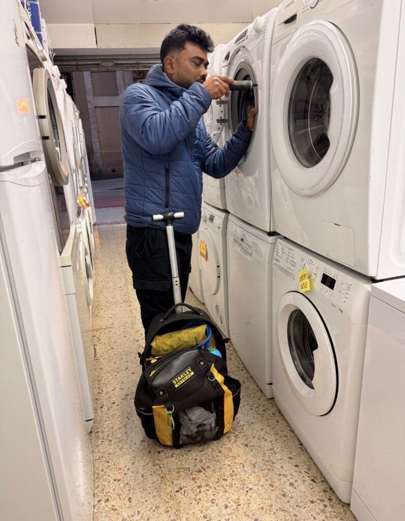 Técnico reparando una lavadora en un establecimiento de Barcelona